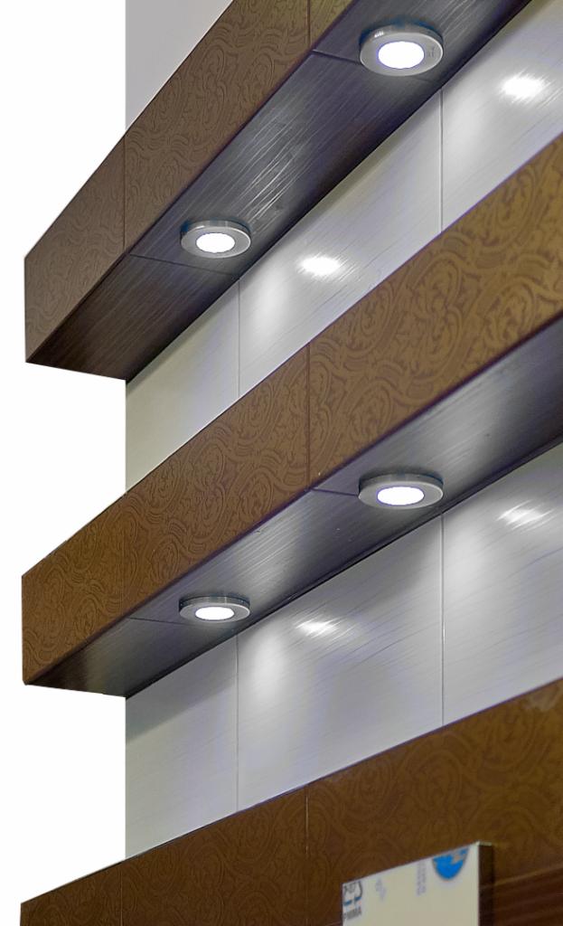 Fragment ściany z dekoracyjnymi półkami z oświetleniem punktowym LED, jasne panele ścienne z delikatną fakturą.