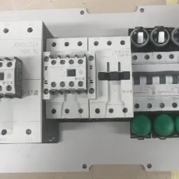 Rozdzielnica elektryczna z zamontowanymi stycznikami Eaton, wyłącznikami różnicowoprądowymi, bezpiecznikami i zielonymi przyciskami, widok z góry.