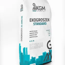 Worek 25kg ekogroszku Standard od KGM Hurtownia Opału, z widocznymi informacjami o wartości opałowej, zawartości popiołu, siarki i wilgoci, ozdobiony niebieską grafiką miejskiego krajobrazu.
