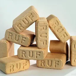 Stos ułożonych kostek brykietu drzewnego RUF na jasnym tle, widoczne charakterystyczne tłoczenia z nazwą producenta.