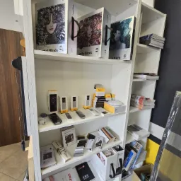 Półka z ekspozycją katalogów i próbek rolet okiennych, żaluzji i moskitier, widoczne foldery reklamowe z nazwami produktów i firmą Vertex S.A.