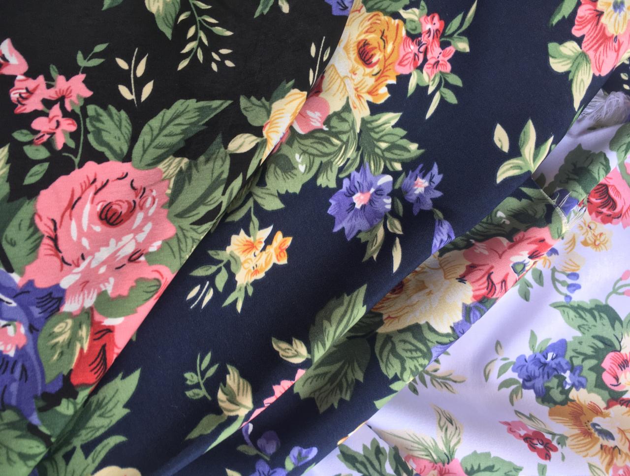 Zestawienie kilku próbek tkanin w kwiatowe wzory, różne kolory tła: czarny, granatowy, biały.