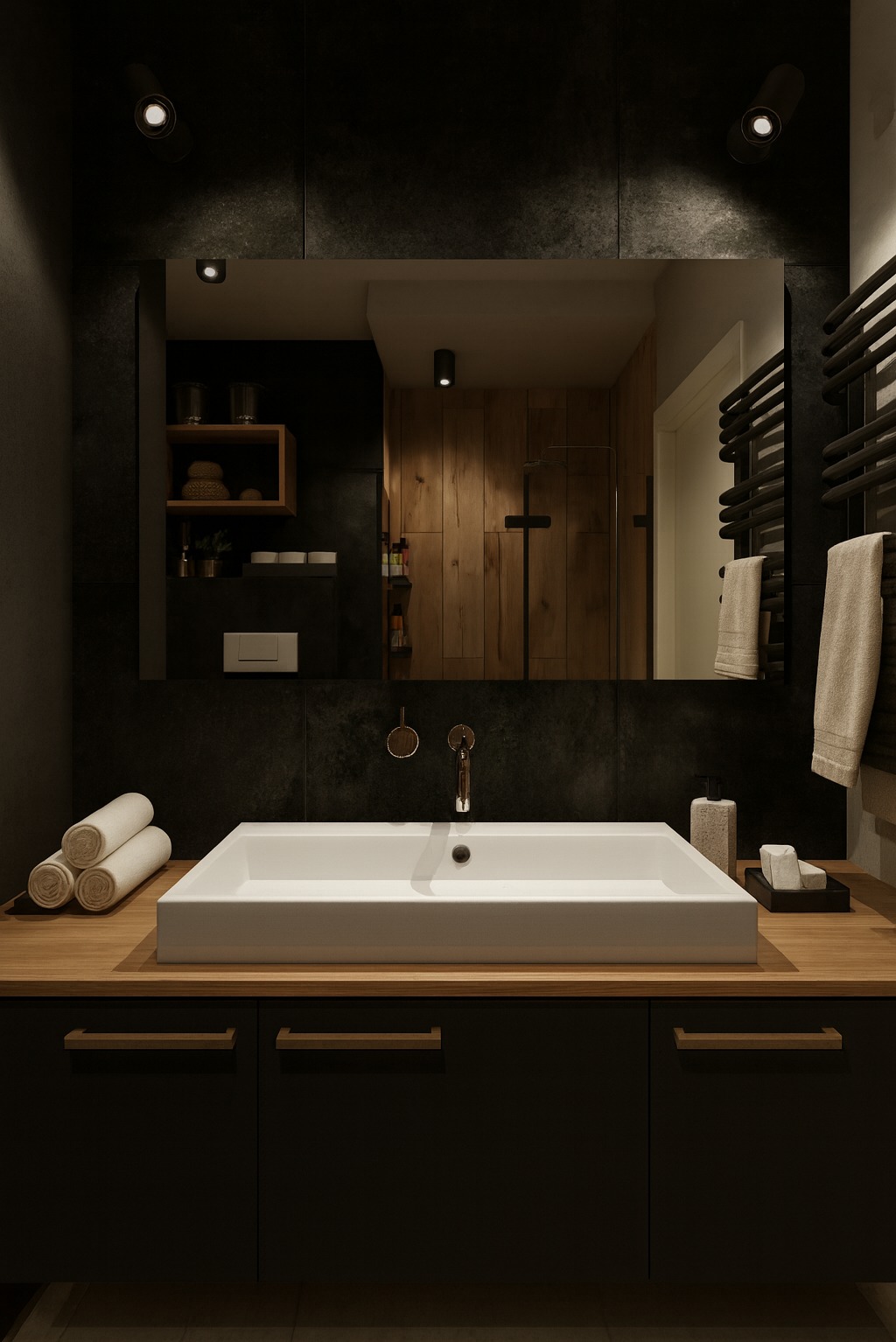 Nowoczesna łazienka z ciemnymi płytkami, drewnianym blatem i białą umywalką. W lustrze odbija się drewniana ściana prysznica i półki z akcesoriami.