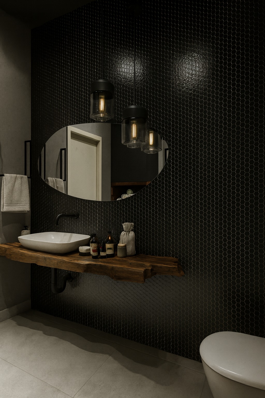 Nowoczesna łazienka z czarną mozaiką heksagonalną, drewnianym blatem pod umywalką i owalnym lustrem podświetlonym trzema lampami wiszącymi. Minimalistyczny design.