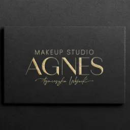 Czarna wizytówka z tłoczonym, złotym napisem 'MAKEUP STUDIO AGNES Agnieszka Wojcik', leżąca na czarnym, teksturowanym tle.