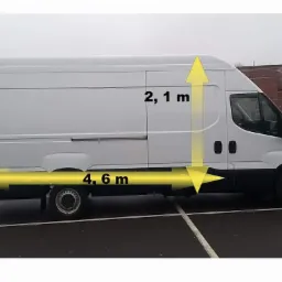 Biały furgon o wymiarach 4,6 m długości i 2,1 m wysokości, zaparkowany na parkingu.