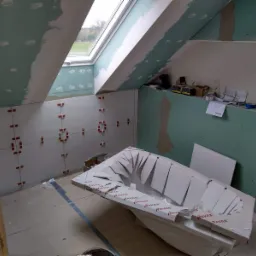 Łazienka w trakcie remontu na poddaszu: zamontowana płyta karton-gips, widoczne szpachlowanie łączeń, nowe okno dachowe i wanna w kartonie marki Ravak.