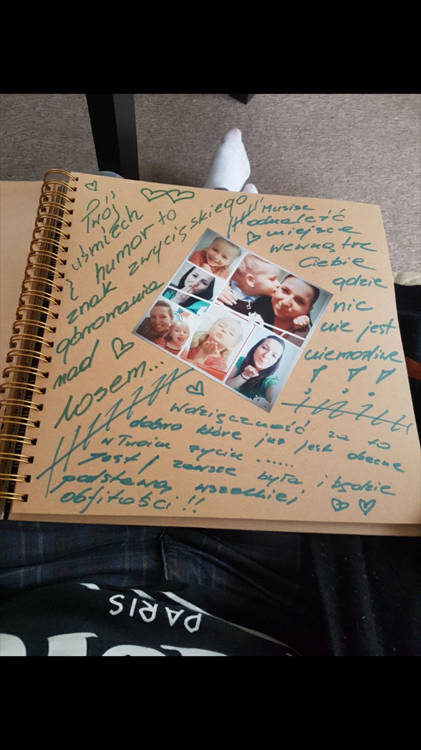 Otwarty, ręcznie robiony album ze zdjęciami i odręcznymi dedykacjami, prawdopodobnie prezent z Warty, leżący na czyichś kolanach.