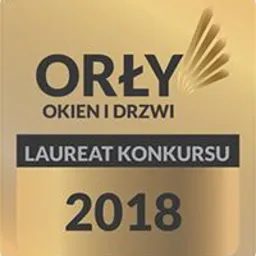 Złota plakietka z napisem 'Orły Okien i Drzwi, Laureat Konkursu 2018' na jasnym tle.