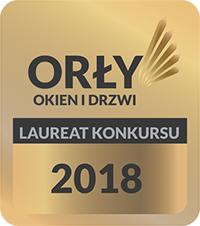 Złota plakietka z napisem 'Orły Okien i Drzwi, Laureat Konkursu 2018' na jasnym tle.