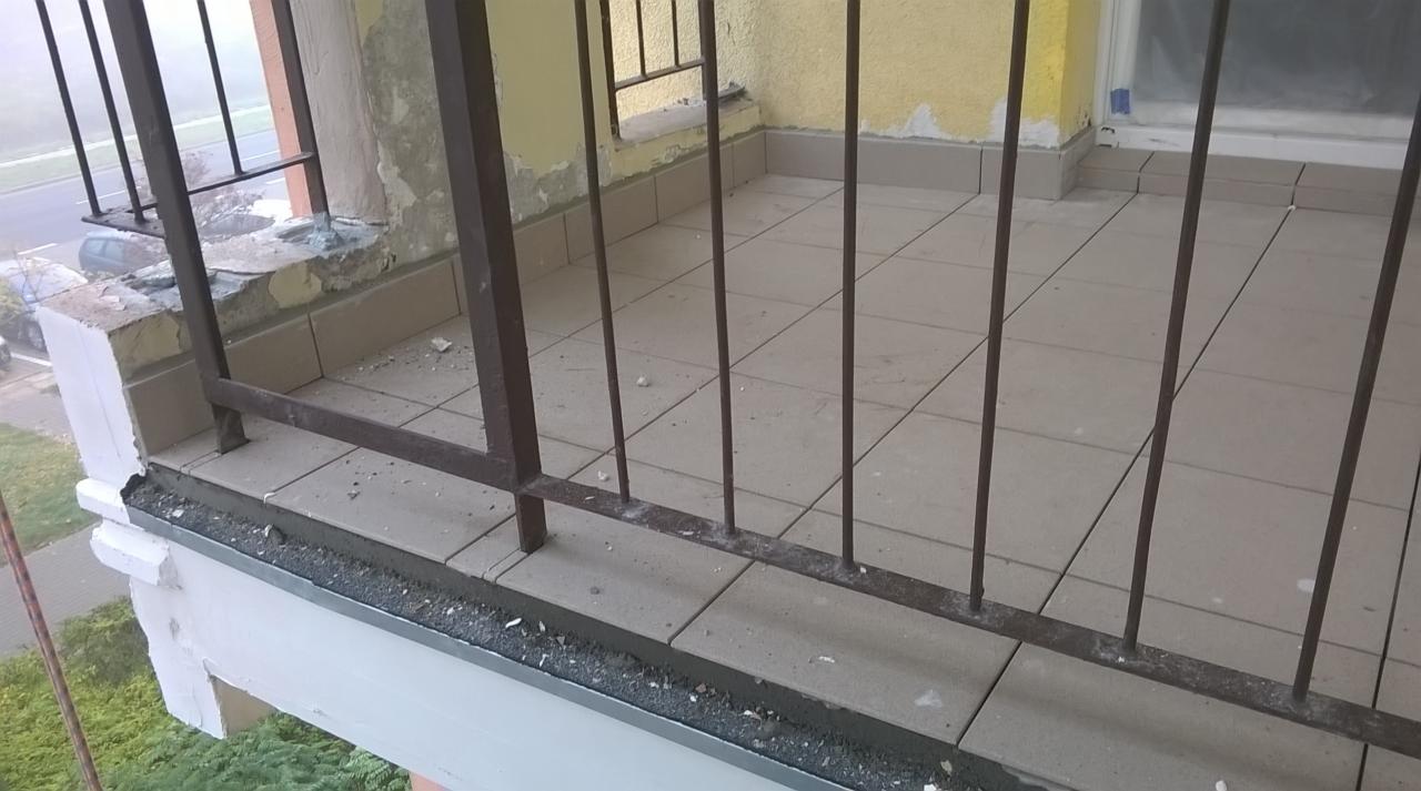 Balkon w trakcie remontu: zniszczona elewacja, obdrapane ściany, stara balustrada i płytki podłogowe czekające na odnowienie.
