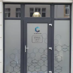 Wejście do biura z naklejkami na szybach, informującymi o ofercie: napisy 'Kredyty', 'Hipoteki', 'Dla firm', 'Bez BIK' oraz logo 'Centrum Gotówki'.