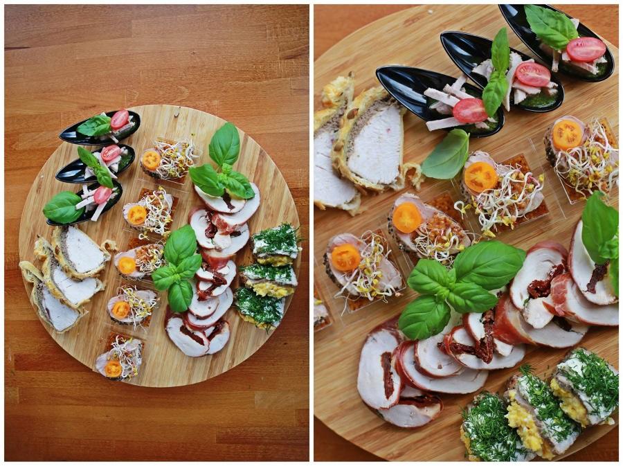 Dekoracyjna drewniana deska z różnorodnymi przekąskami: roladki mięsne z suszonymi pomidorami, kanapeczki z kiełkami, mięso w cieście francuskim i przystawki w czarnych łyżeczkach, całość...