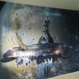 Fototapeta w pokoju dziecięcym przedstawiająca statek kosmiczny na tle Ziemi widzianej z kosmosu, niebieskie ściany, lampa sufitowa w kształcie chmury.