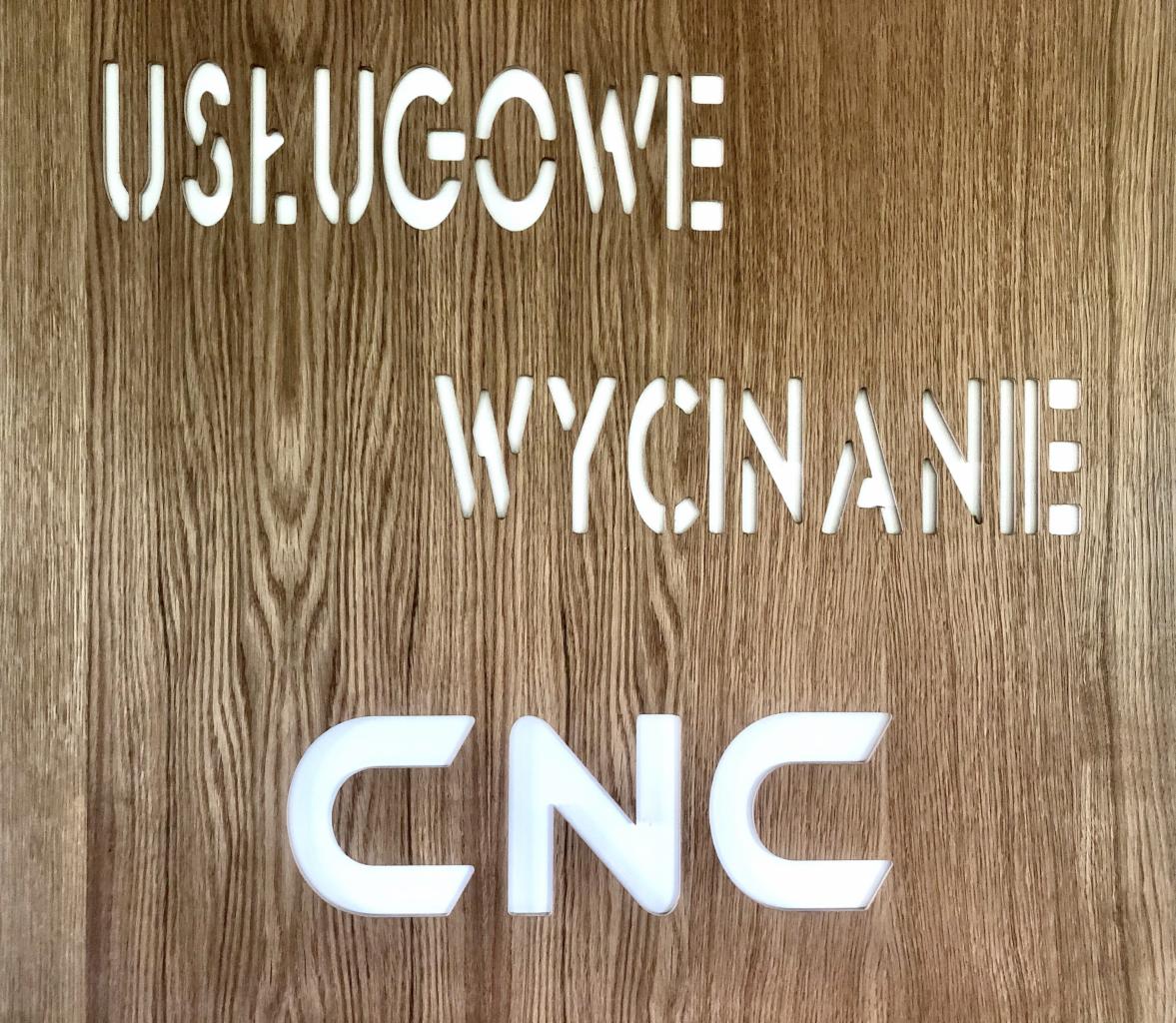 Drewniana tablica z napisem 'Usługowe Wycinanie CNC', wykonanym różnymi technikami: wycinane litery i naklejane plastikowe litery na tle tekstury drewna.