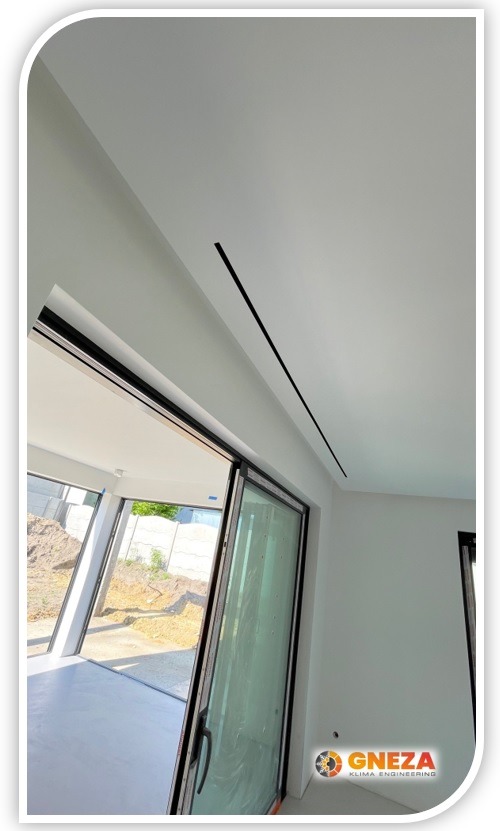 Minimalistyczne, czarne linie sufitowe w nowoczesnym wnętrzu z przesuwnymi drzwiami balkonowymi, widoczne logo firmy GNEZA KLIMA ENGINEERING.