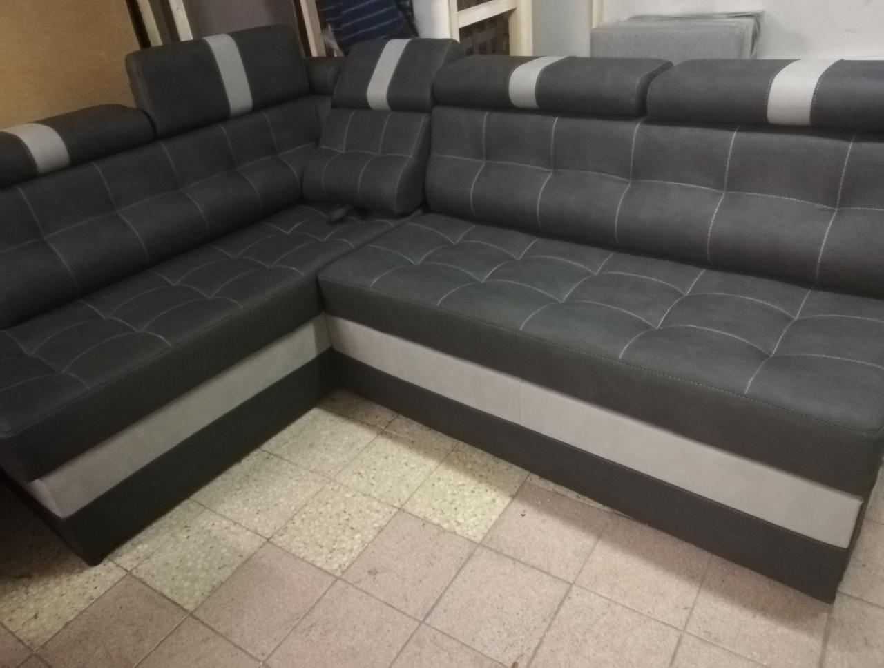 Ciemnoszary narożnik z funkcją relax, pikowane siedzisko i oparcie, jasnoszary pas na dole i na zagłówkach, widoczne szwy w kolorze ecru.