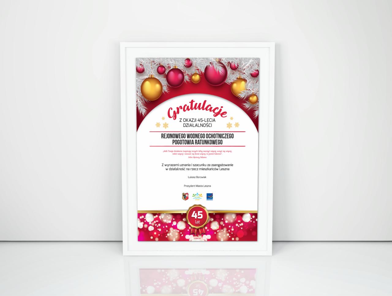 Oprawiony w ramkę dyplom gratulacyjny z okazji 45-lecia Rejonowego Wodnego Ochotniczego Pogotowia Ratunkowego, z motywami świątecznymi i podpisem Prezydenta Miasta Leszna.