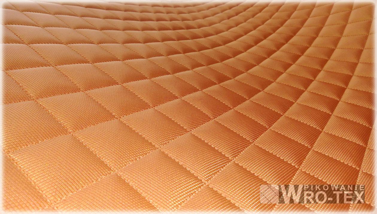 Pomarańczowa, pikowana tkanina w romby z widocznym logo producenta WRO-TEX w prawym dolnym rogu.