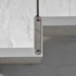 Pracownia Snycerska u Pawła - Szczegółowe ujęcie białych, modułowych schodów z metalowym mocowaniem poręczy na tle białej, ceglanej ściany.