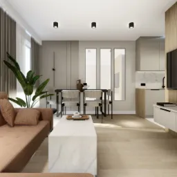 Jasne wnętrze salonu z aneksem kuchennym, beżowa sofa, biały stolik kawowy z marmurowym wzorem, stół jadalny z krzesłami, minimalistyczna zabudowa kuchenna, drewniana ściana z telewizorem.