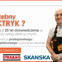 Portret uśmiechniętego mężczyzny w okularach, w kombinezonie roboczym z miernikiem zawieszonym na szyi, na tle grafiki reklamowej z hasłem 'Potrzebny elektryk?' i logotypami firm.