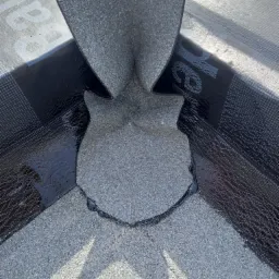 Szczegółowe ujęcie kosza dachowego z papy bitumicznej z posypką mineralną, zabezpieczonego czarnym pasem hydroizolacyjnym, Bolszewo.