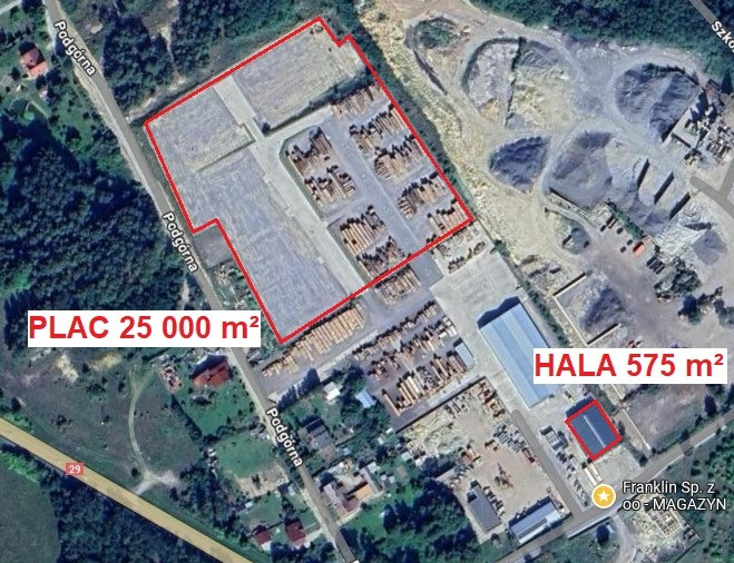 Widok z lotu ptaka na teren przemysłowy z placem o powierzchni 25000 m² i halą o powierzchni 575 m², otoczony zielenią i drogami.