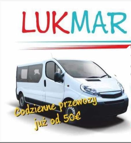 Biały bus z napisem 'Codzienne przewozy już od 50€' i logo firmy LUKMAR nad nim.
