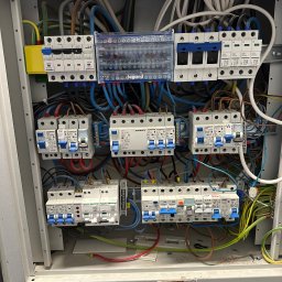 Oględziny rozdzielnicy elektrycznej w lokalu usługowym podczas przeglądu.