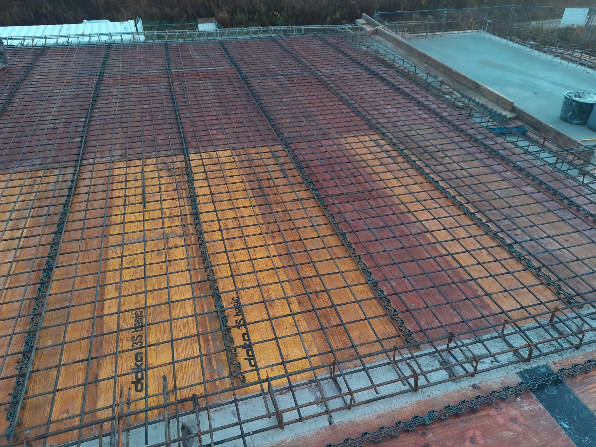 Zbrojenie stropu na deskowaniu systemowym Doka 3S basic, widok z góry na siatkę z prętów stalowych przygotowaną do zalania betonem.