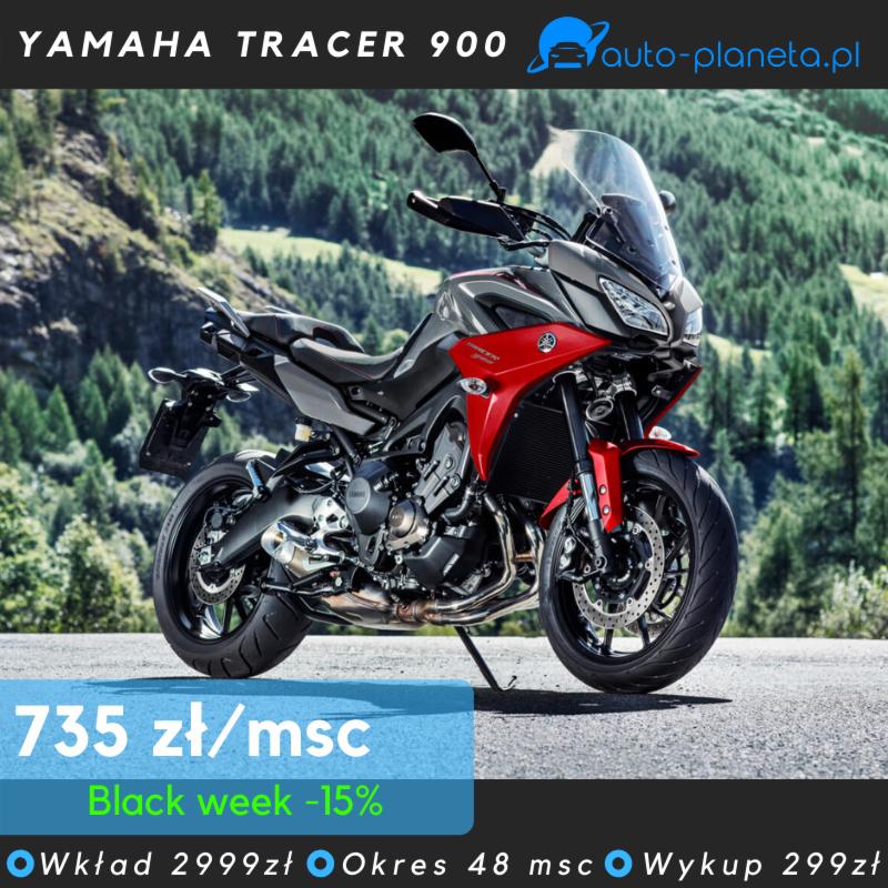 Motocykl Yamaha Tracer 900 w kolorze czerwono-szarym na tle górskiego krajobrazu, z widoczną ofertą promocyjną na dole zdjęcia.