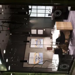 Widok na wnętrze salonu jubilerskiego ACLARI Diamonds przez szklaną witrynę, z widocznym logo firmy na szyldzie i plakatami z pierścionkami na ścianie.