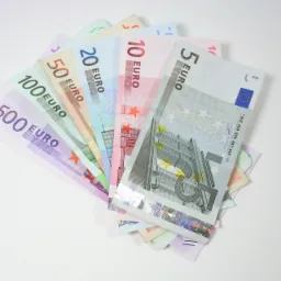 Ułożony wachlarz banknotów euro o nominałach od 5 do 500 na białym tle.