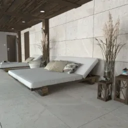 Relaksacyjna strefa SPA z dwoma leżankami z szarego drewna i białymi materacami, dekoracyjnymi poduszkami, wysokimi trawami w wazonach i lampionami w stylu skandynawskim.