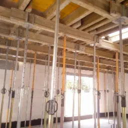 Wnętrze budynku w Borucinie w trakcie budowy, widoczne szalunki stropowe i podpory pionowe, ściany z białego bloczka.