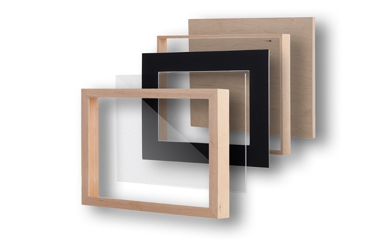 Rozłożone warstwy ramy: surowe drewno, szkło, czarny karton, drewniana płyta. Produkcja.