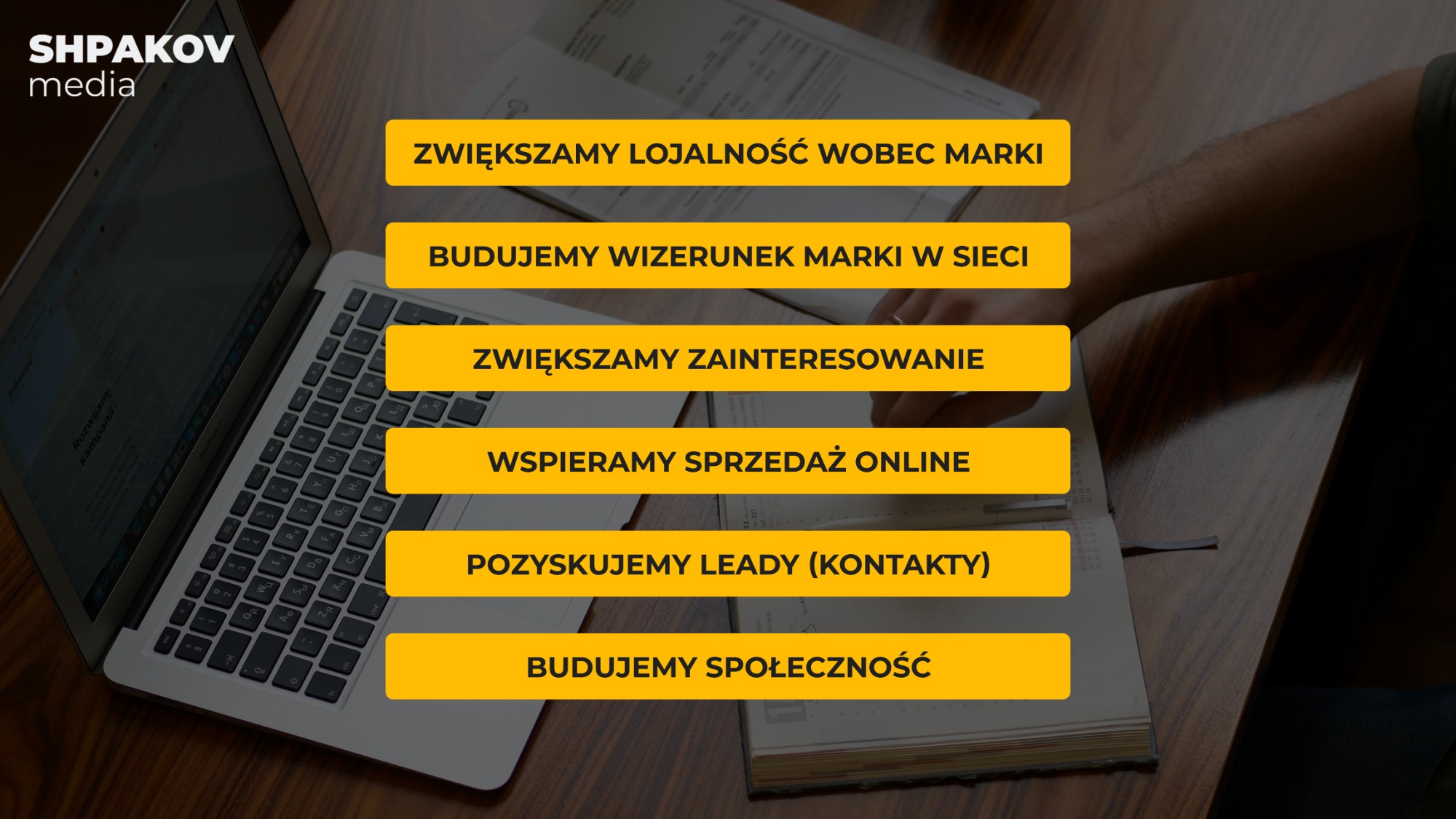 Laptop z otwartą stroną prezentującą hasła marketingowe: Zwiększamy lojalność wobec marki, Budujemy wizerunek marki w sieci, Zwiększamy zainteresowanie, Wspieramy sprzedaż online, Pozyskujemy leady...