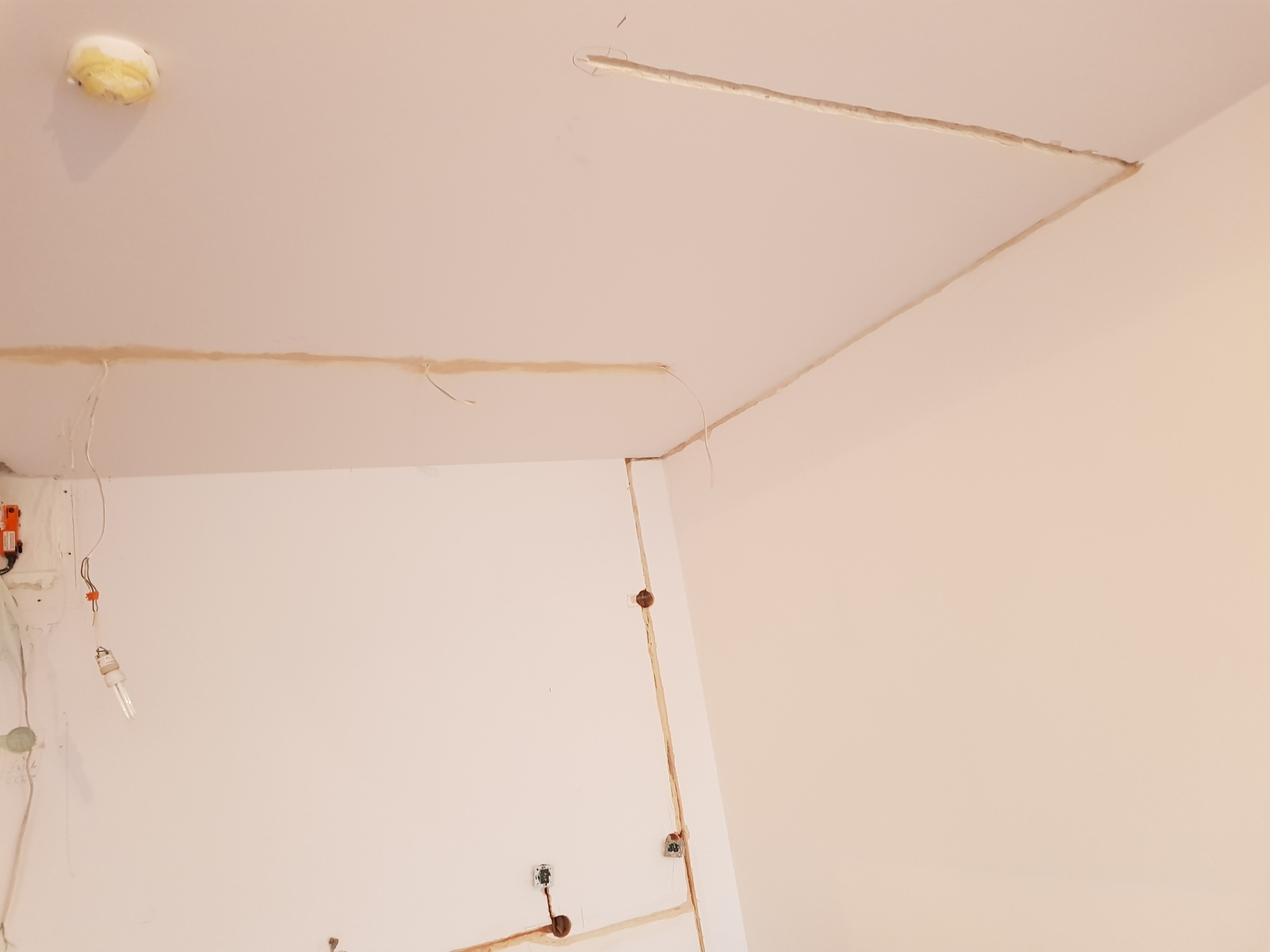 Przygotowanie do malowania: widoczne szpachlowane łączenia płyt kartonowo-gipsowych na suficie i ścianach, wystające przewody elektryczne, otwór po lampie sufitowej.