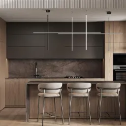 Nowoczesna kuchnia z wyspą i trzema hokerami, oświetlona geometryczną lampą wiszącą, z fornirem drewnianym i marmurowym blatem.