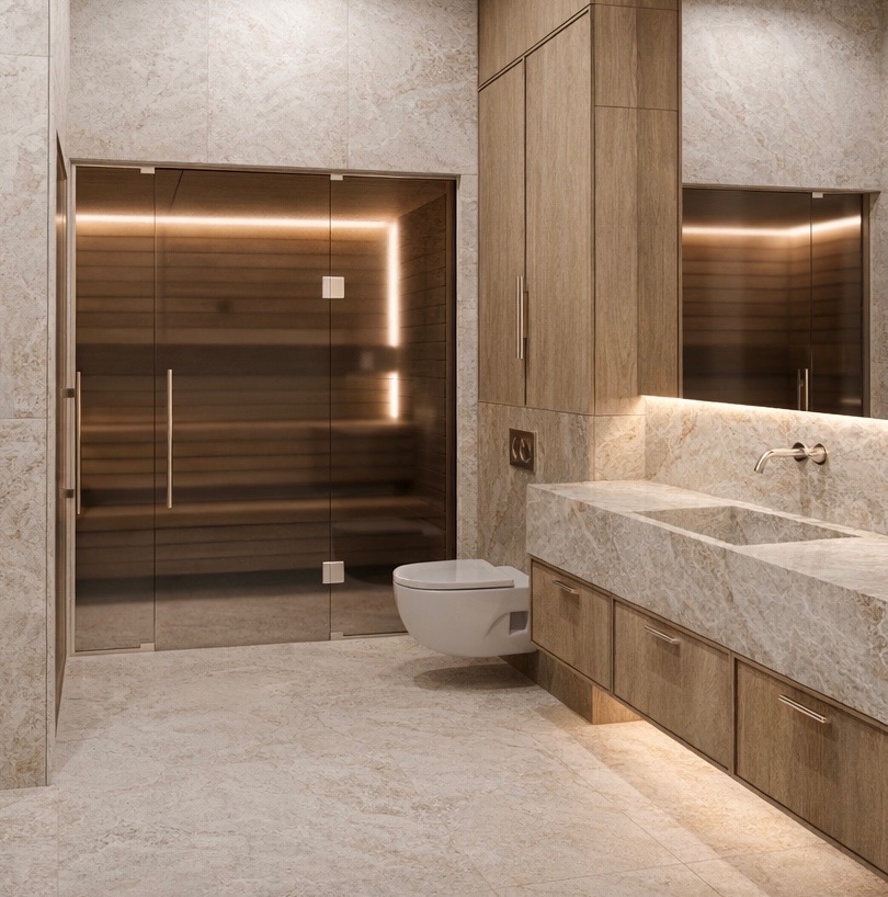 Nowoczesna łazienka z sauną: przeszklone drzwi sauny z podświetleniem LED, marmurowa umywalka z szafkami z drewna i podwieszana toaleta. Całość w beżowej tonacji.