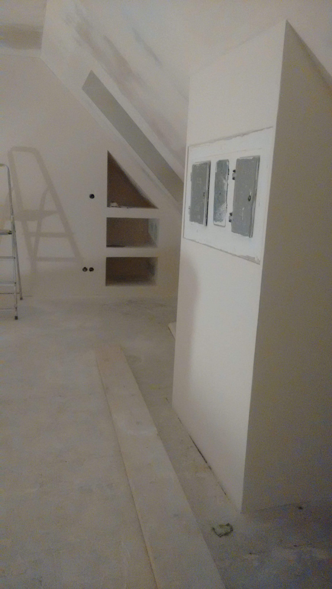 Skośne poddasze po pracach w Żywcu: ściany przygotowane pod wykończenie, widoczne wnęki i zabudowa z płyt gipsowych. Prace w toku, surowy stan.