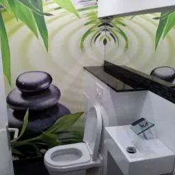 Nowoczesna łazienka z toaletą, umywalką i fototapetą z motywem kamieni zen i liści bambusa.