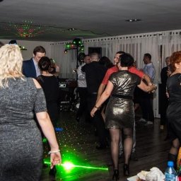 D.J.Victor - Tańczący goście na parkiecie podczas imprezy z zielonymi laserami. W tle widoczne białe zasłony i oświetlenie.