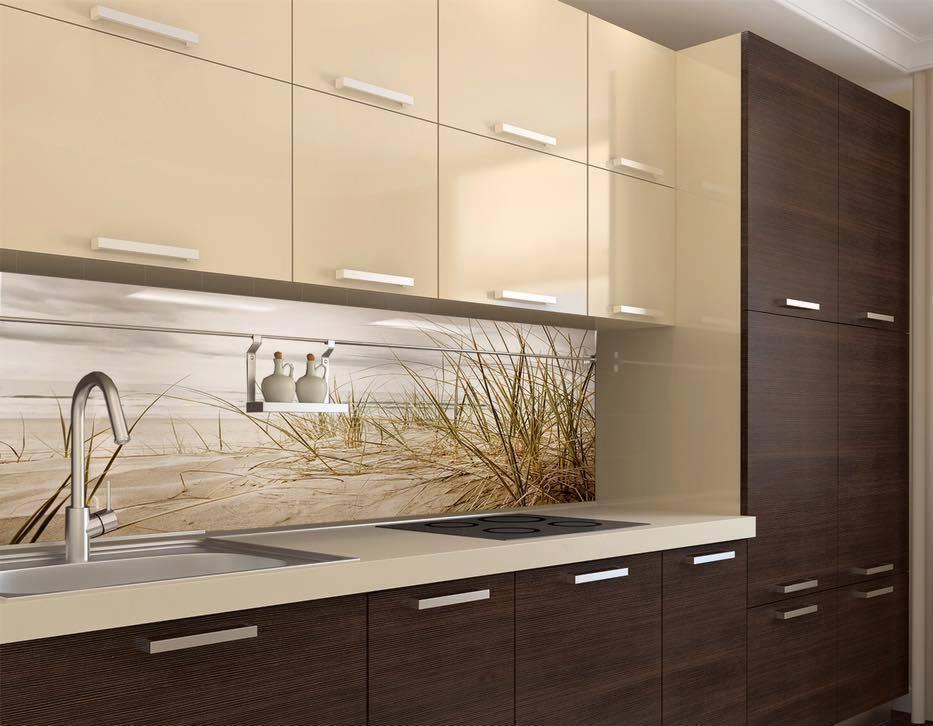 Nowoczesna kuchnia z beżowo-brązowymi szafkami i panelem szklanym nad blatem z motywem plaży z trawami, widoczne minimalistyczne uchwyty i chromowana bateria.