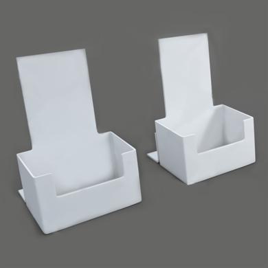 Dwa białe, puste stojaki na ulotki z tworzywa sztucznego ustawione na szarym tle, prezentujące minimalistyczny design.