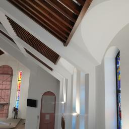 Efekt końcowy sufitu podwieszanego z montażem drewnianych belek oraz wykonanie podwójnego łuku nad oknami 