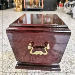 Drewniana urna pogrzebowa – klasyczna i elegancka, z ozdobnymi uchwytami, solidnie wykonana.