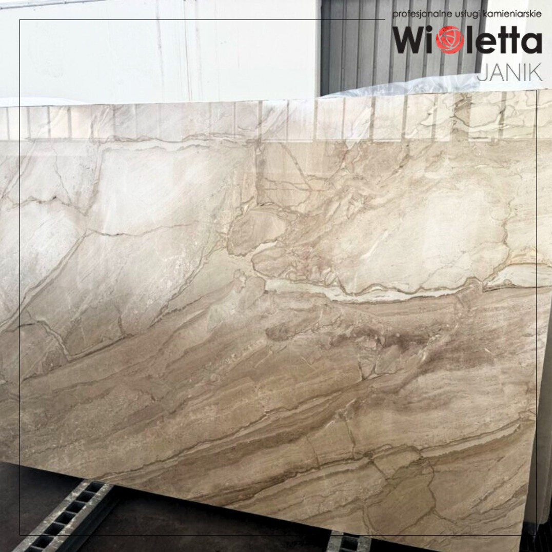 Surowy blok marmuru i granitu o unikalnym wzorze żyłkowania, przygotowany do obróbki kamieniarskiej. Widoczne detale powierzchni i logo firmy.