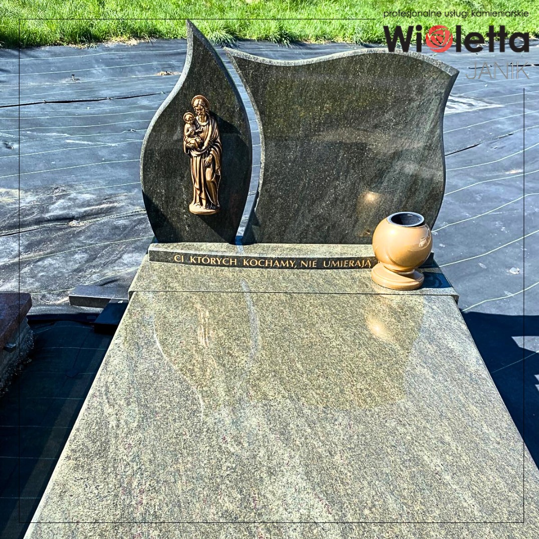 Granitowy nagrobek z rzeźbą Matki Bożej i wazonem, na czarnej macie. Napis: 'CI KTÓRYCH KOCHAMY, NIE UMIERAJĄ'.